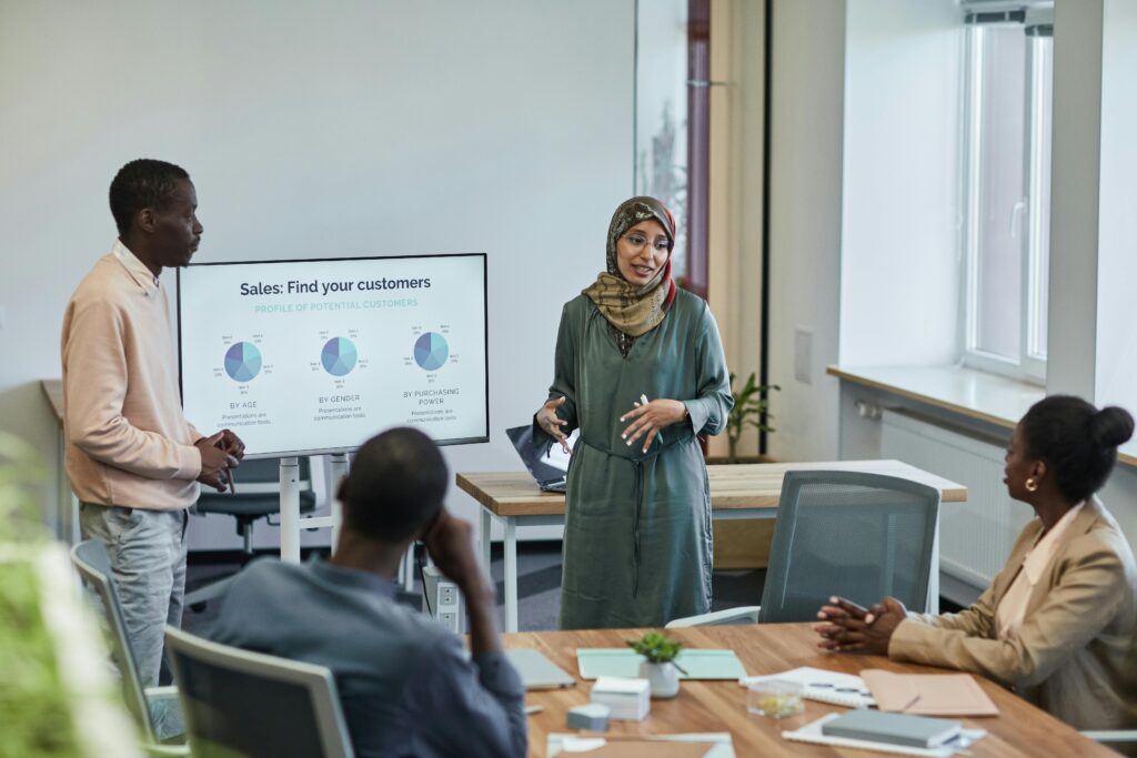 Colleagues in a professional setting attending sales training led by two presenters.